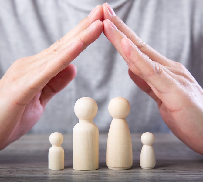 Family life and property insurance concept. Wooden figurines representing family